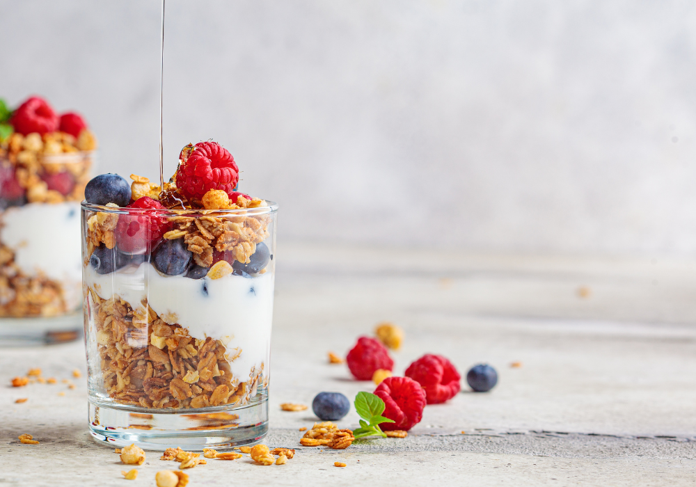 granola entre camadas de yogurt e frutas  dentro de um copo de vidro