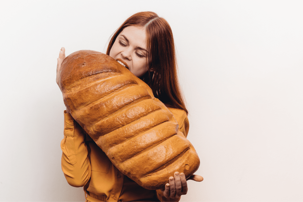 mulher comendo um pão gigante