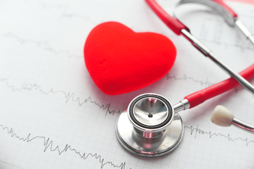 um estetoscópio e um coração encima de de cardiograma