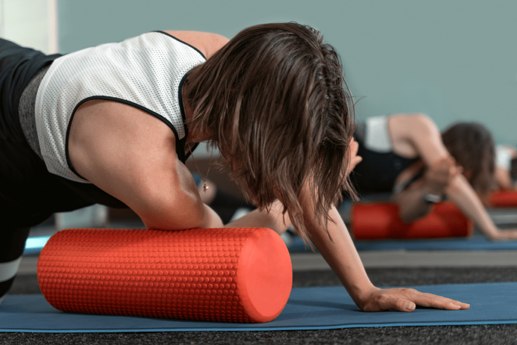 mulher usando ferramenta de massagem para terapia miofascial nos ombros